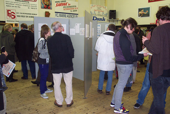 Is het een doolhof? Zijn het toeristen die de weg kwijt zijn? Nee,
	het is een expo
	van alle 
	inzendingen.